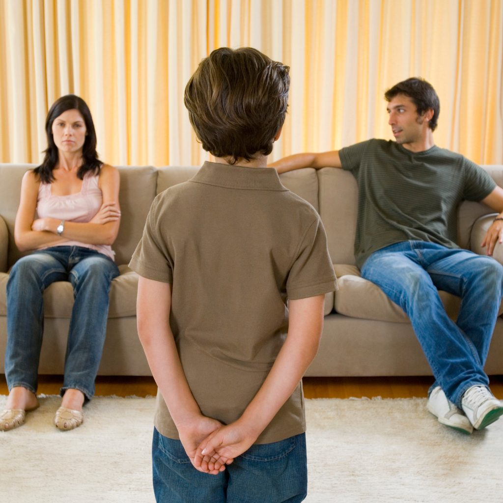 Divorced parents on couch making co-parenting decision about son.