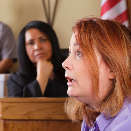 Woman in front of judge dropping a Massachusetts Restraining Order.