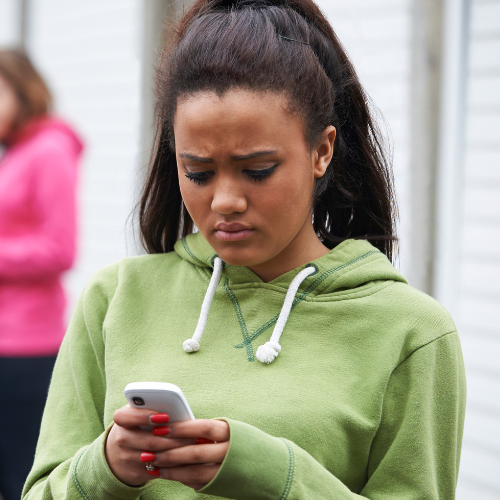 Woman reading harassing text message in Massachusetts.