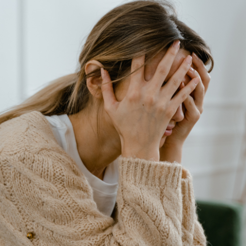 Woman with her hands covering her face thinking about the abuse prevention law in Massachusetts.
