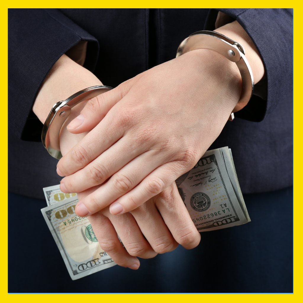 Man in handcuffs holding money that he will use to post bail in his Massachusetts criminal case.