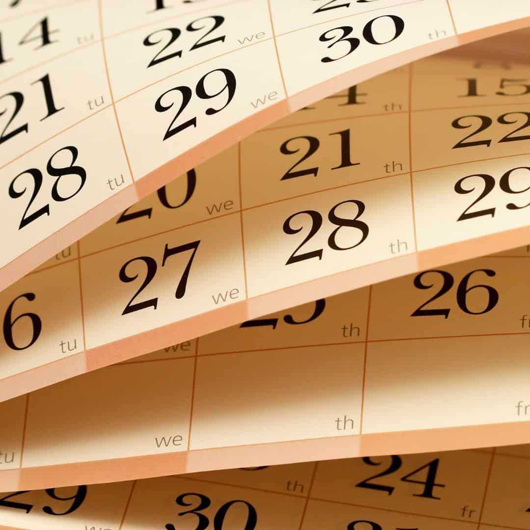 Massachusetts legal services - A calendar with multiple pages turned, showing dates in black on a beige background.