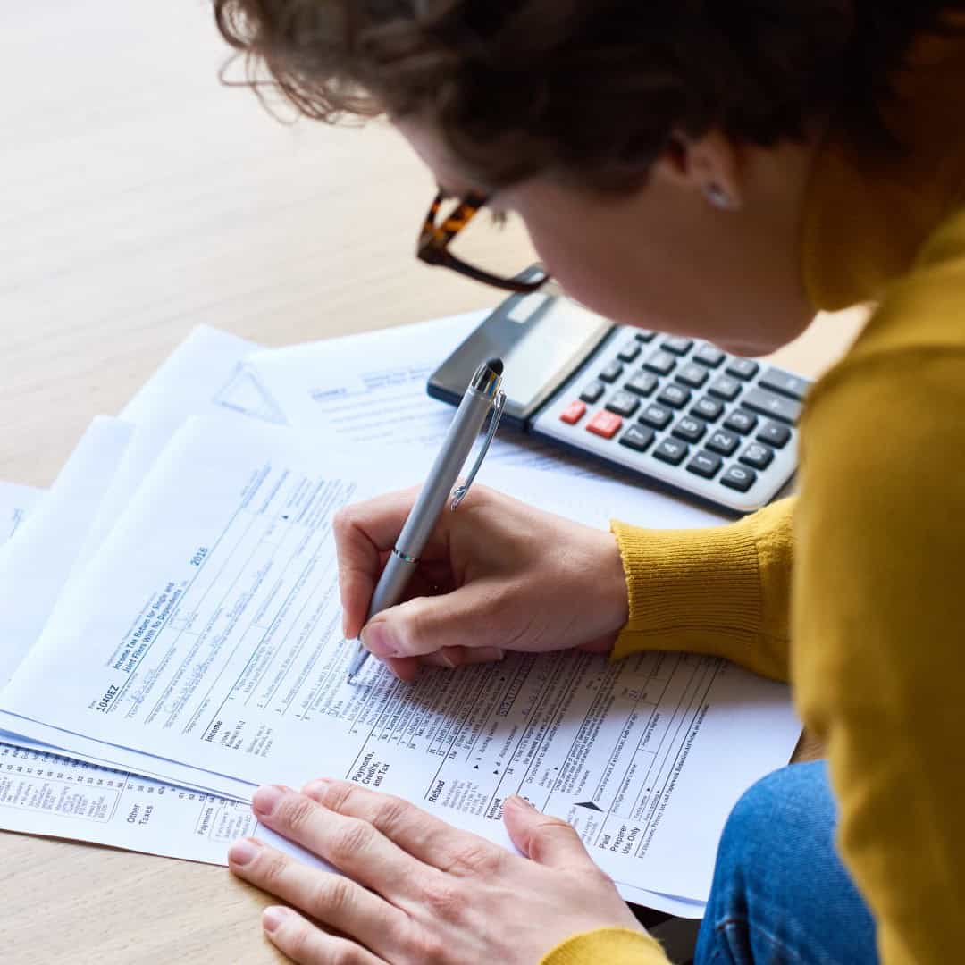 Massachusetts legal services - A person reviewing legal documents with a calculator and pen on a desk.