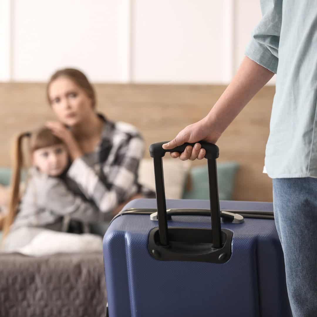 Resources 11 Massachusetts legal services - A person holding a suitcase with a worried woman and child in the background.