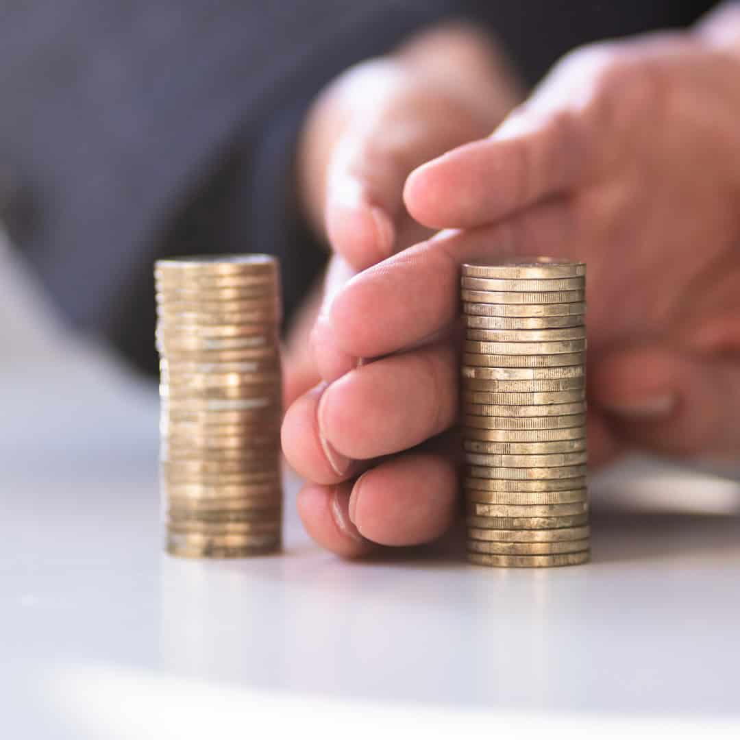 Massachusetts legal services - A person stacking coins, symbolizing financial growth or legal financial planning in Massachusetts.