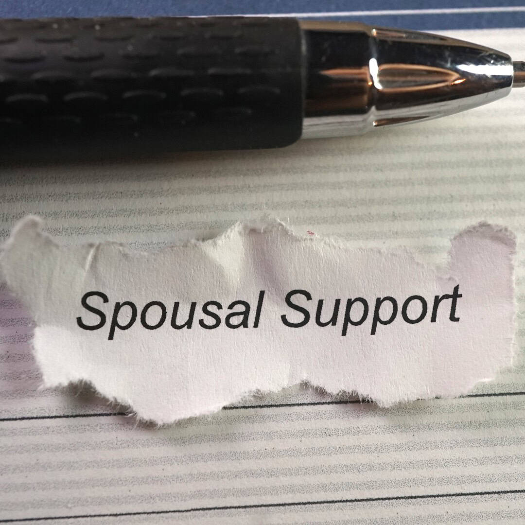 Massachusetts legal services - A torn piece of paper with "Spousal Support" written on it, placed on a desk with a pen.