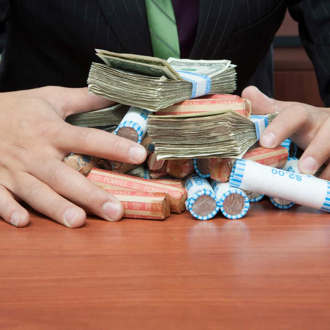 Resources 3 Massachusetts legal services - Stacks of cash, coins, and rolled bills on a wooden table, symbolizing financial or legal matters.