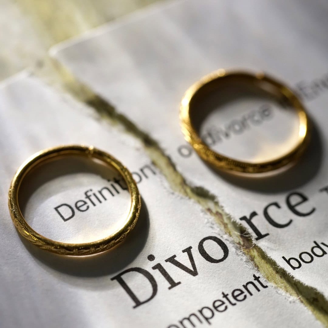 Resources 5 Massachusetts legal services - AALT tag (STRICTLY maximum 100 characters): Two gold wedding rings on a torn divorce document, symbo.