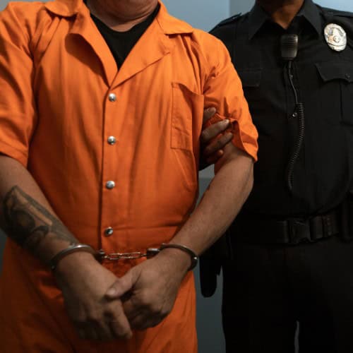 Man in orange jumpsuit and handcuffs being sentenced for violating a Massachusetts Restraining Order.
