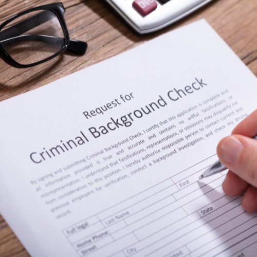 Man filling out a criminal background check application in Massachusetts.