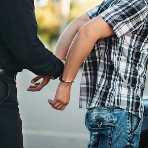 Police officer placing man in handcuffs for violating a 209A in Massachusetts.